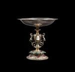 Coupe en argent partiellement dorée et émaillée à décors néo-Renaissance. La base circulaire bordée d’un décor de feuillage stylisé. Le piédouche ciselé d’enroulements de feuilles de lierre sur fond a