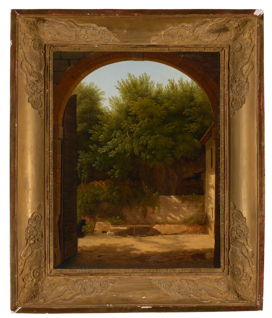 A view of a sunlit courtyard with a trough, seen through an archway