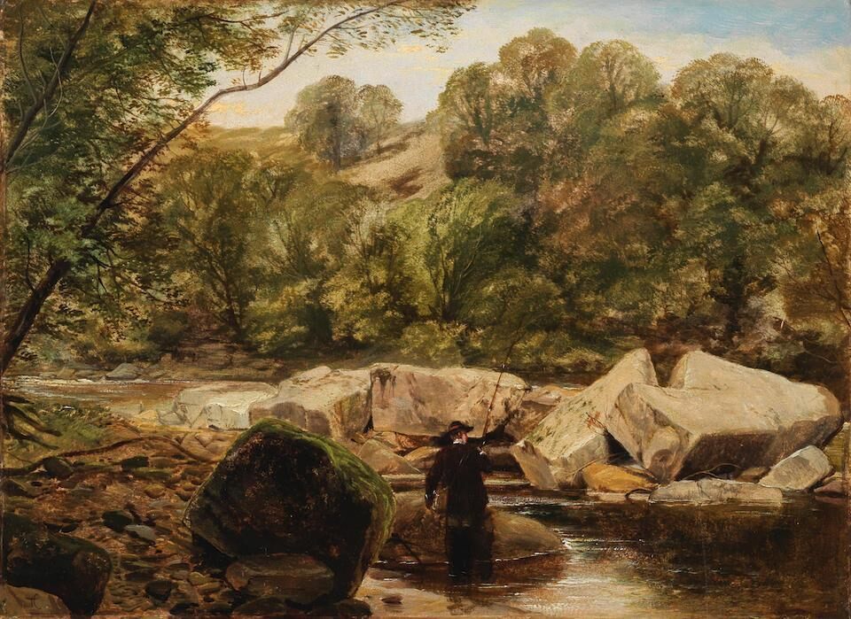 A fisherman wading in a rocky river