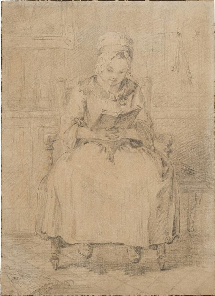 A little girl, seated, reading a book