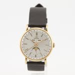 Montre Cosmic Triple calendrier phase de lune ref. 2473 circa 1947 Boîtier rond en or jaune 14 K (585‰) cadran argenté à petite seconde et phase de lune à 6 heures, guichet à 12 heures pour le jour et