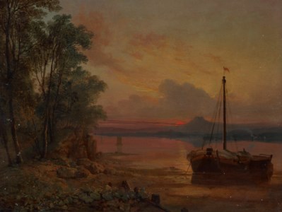 An estuary at sunset with a moored fishing boat in the foreground
