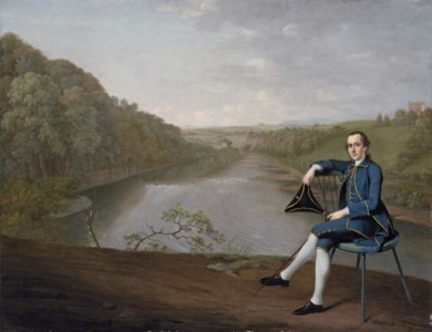 Portrait of Philip Howard of Corby Castle, Cumberland, small full-length, in a blue coat, seated holding a tricorn hat in his right hand, on the banks of the River Eden, Corby Tower beyond