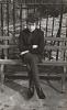 An unpublished photograph of Bob Dylan on bench in Sheridan Square. 1965
