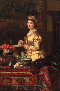 An interior with a lady standing by a table, holding an apple