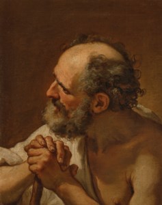 A bearded man, bust-length, his hands resting on a wooden staff