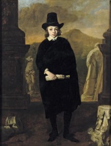 Portrait of a young man, full-length, in a black costume and hat, standing amongst classical sulpture, a landscape beyond