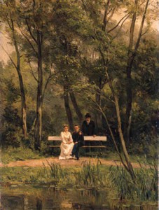 An elegant couple seated on a bench in a park with an attendent standing nearby
