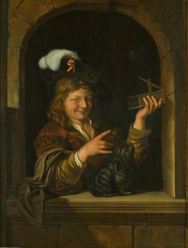 A boy holding a mousetrap with a cat at a window