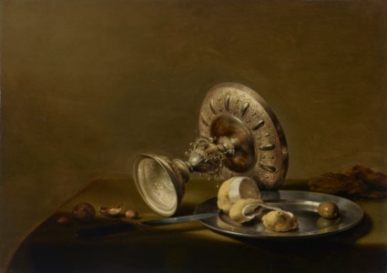 An overturned silver tazza, a partly peeled lemon and an olive on a silver plate, walnuts, hazelnuts and a knife on a draped table