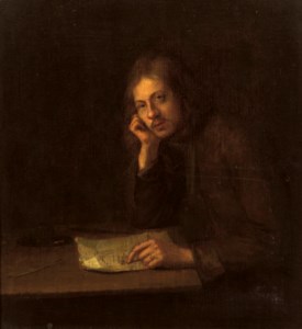 A man seated at a table pointing to a letter