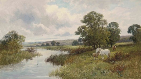 A mare and her foals grazing at the side of a river