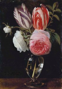 Two parrot tulips, two white roses and a pink rose in a glass vase on a wooden ledge