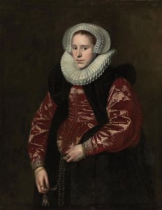 Portrait of a lady, half-length, in a lace bonnet, ruff, red gown with a black velvet mantle, holding a jewelled gold pomander