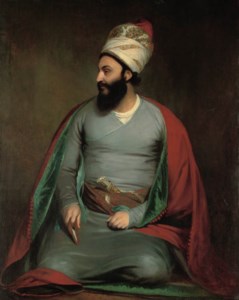 Portrait of Mirza Abu'l Hassan Khan, Envoy Extraordinary and Minister Plenipotentiary to the Court of King George III, kneeling in a red cloak with a blue lining, and a white and red embroidered floral turban, holding a Koran in his right hand