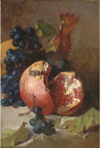 A pomegranate and a bunch of grapes on a ledge