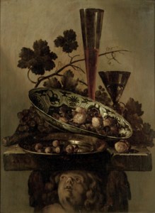 A porcelain bowl with walnuts, a pewter dish with hazelnuts and a 'Façon de Venise', all on a cherub styled pedestal