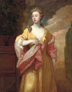Portrait of a lady, three-quarter-length, in a yellow dress with a pink shawl, in a formal garden by an orange tree