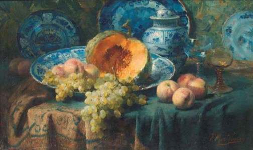 A pumpkin, peaches, and grapes in a china bowl by glasses on a draped table