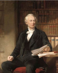 Portrait of Octavius Wigram, three-quarter-length, seated in a black suit, holding a letter, in a library