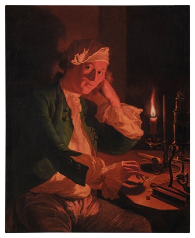 A scientist seated at a desk by candlelight