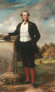 PORTRAIT OF BEILBY RICHARD LAWLEY, 2ND BARON WENLOCK, FULL-LENGTH, IN A BROWN SUIT WITH A WHITE WAISTCOAT, STANDING ON THE TERRACE AT ESCRICK HALL