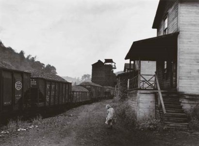 Unemployed miner's daughter carrying home can of kerosene past company housing, Scottsrun, W. Va.