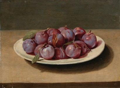 Plums on a white dish on a table