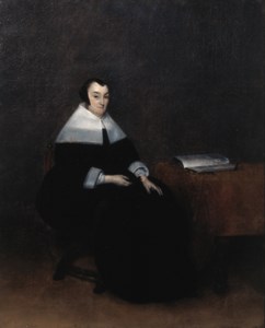 Portrait of an elderly woman, seated small full length by a table, wearing a black dress with lace collar and cuffs and a bonnet