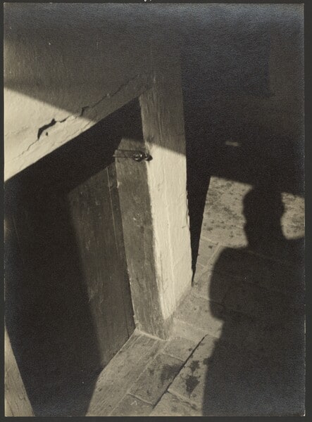 [Shadow of figure beside door]