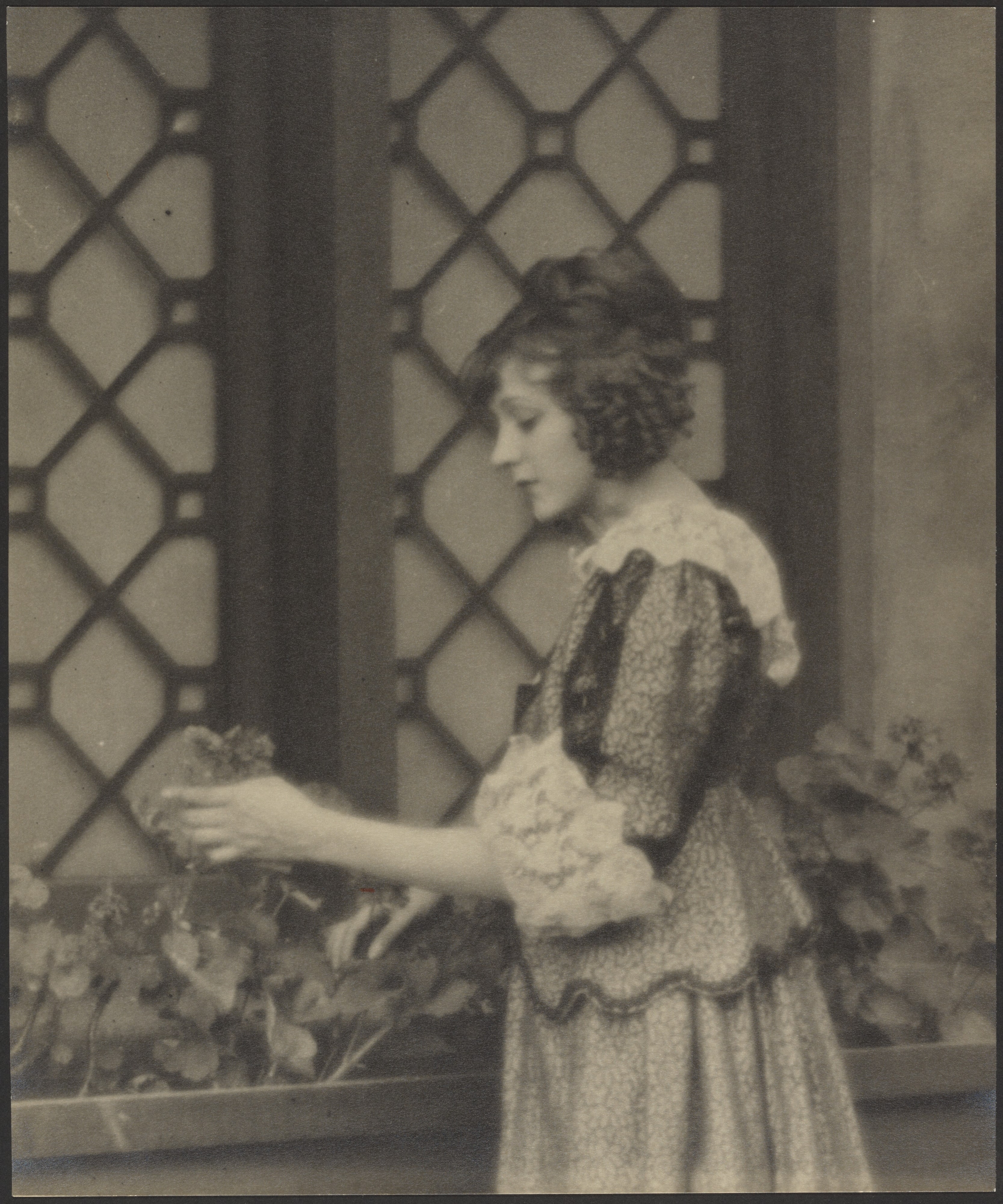 [Woman in Peasant Dress Touching a Flower on a Window Sill]