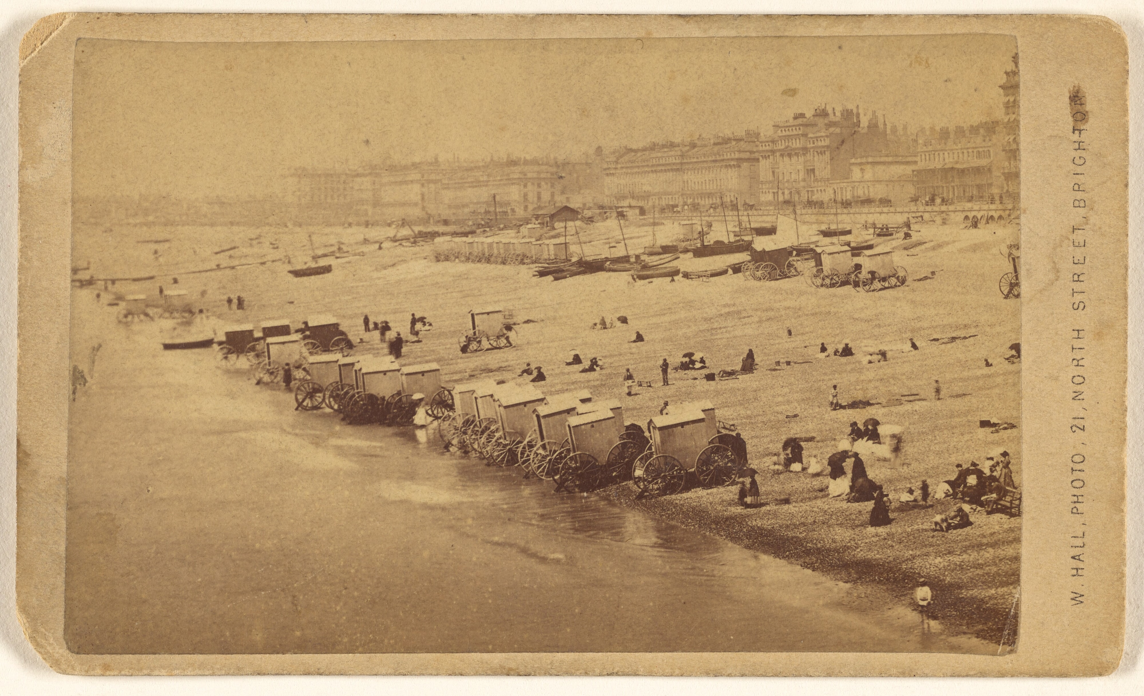 [Beach scene showing bathing cabinets at shoreline, Brighton, England]