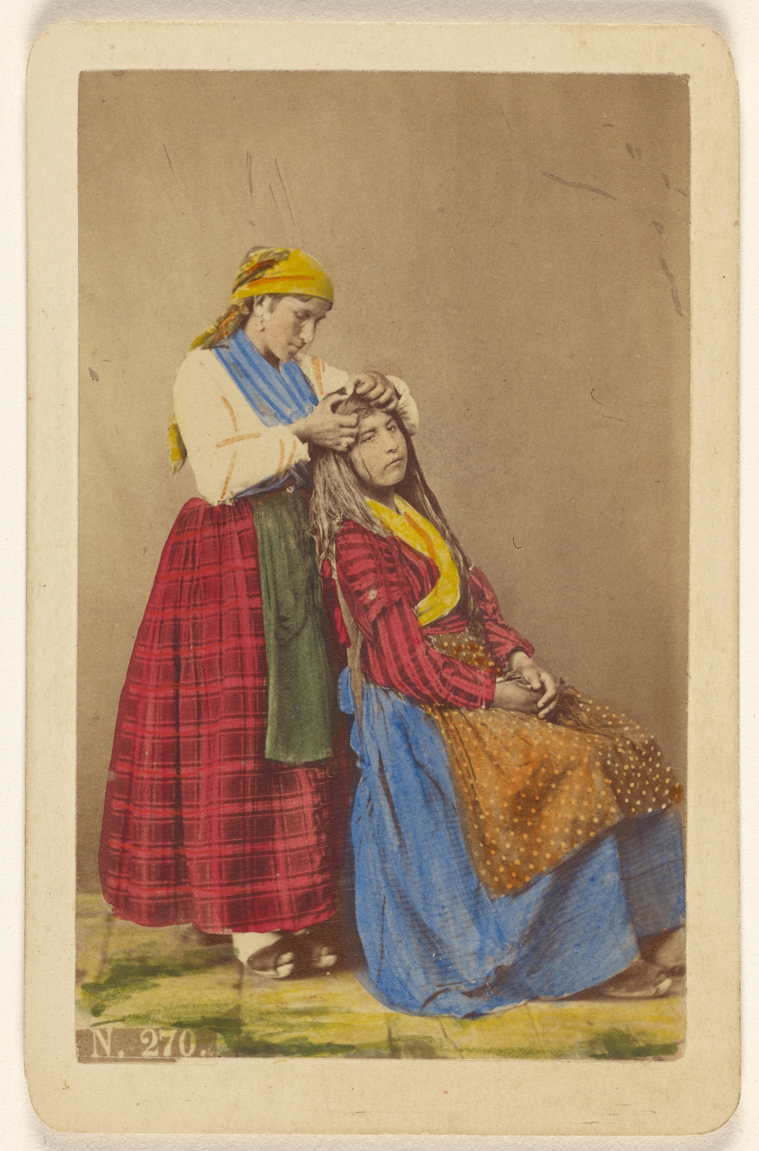 [Older woman doing the hair of a younger woman].
