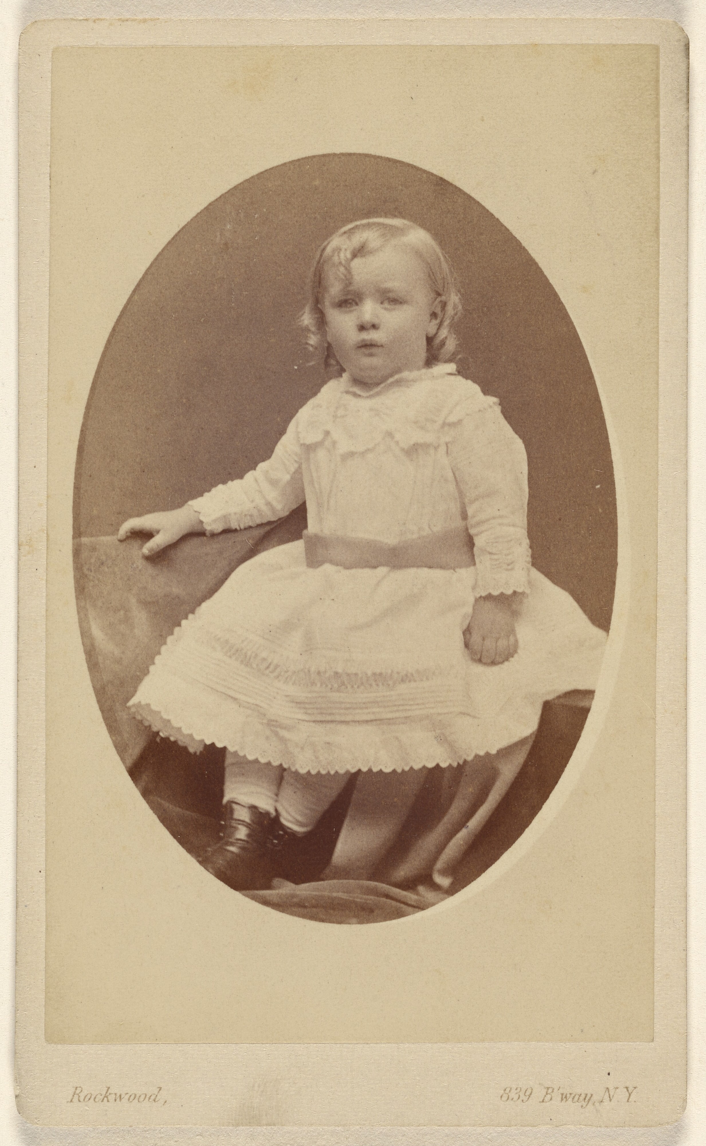 [Unidentified little girl seated, in oval style]