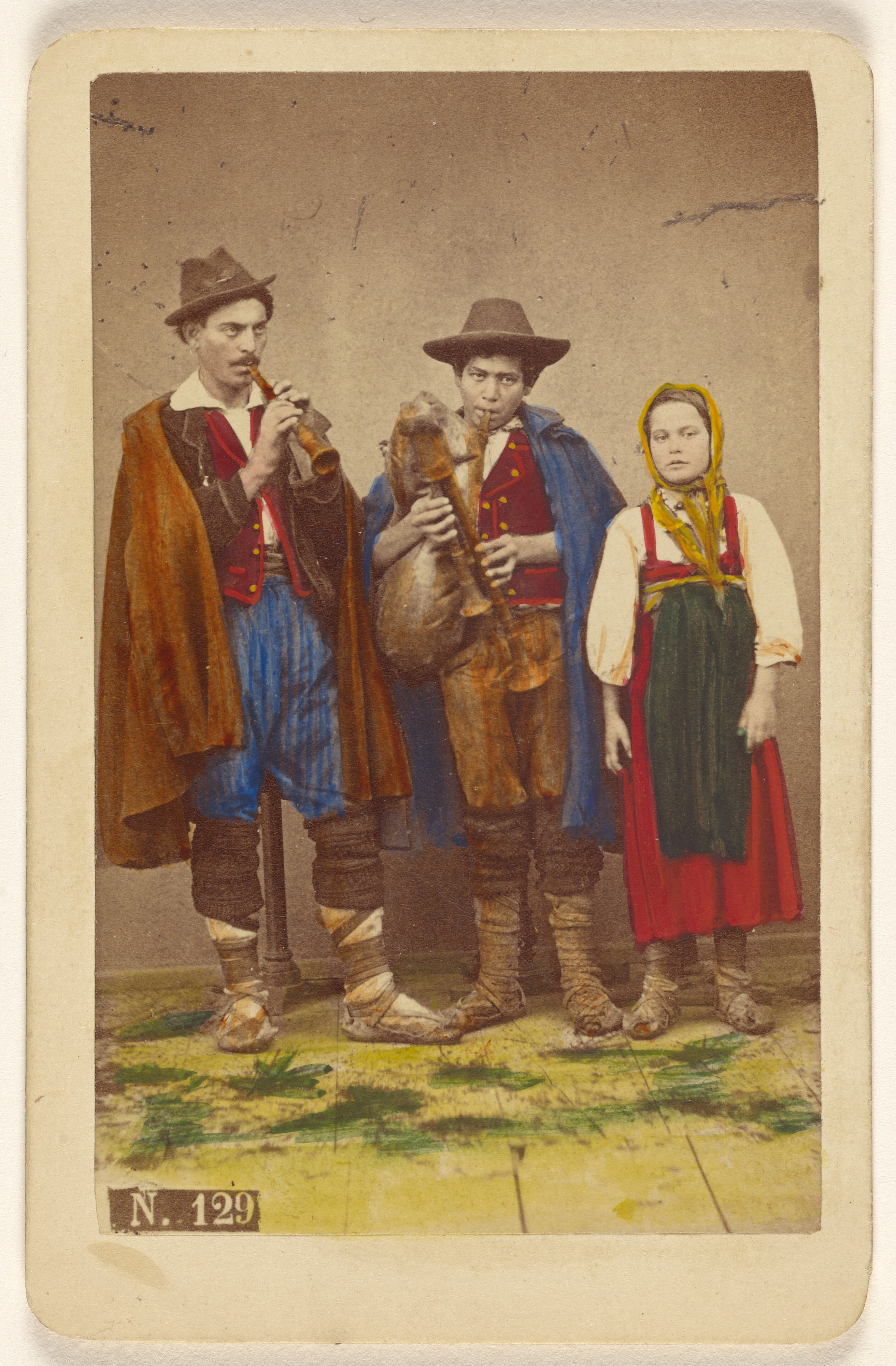 [Three Italian peasants standing: two men playing wind instruments, a girl next to them]