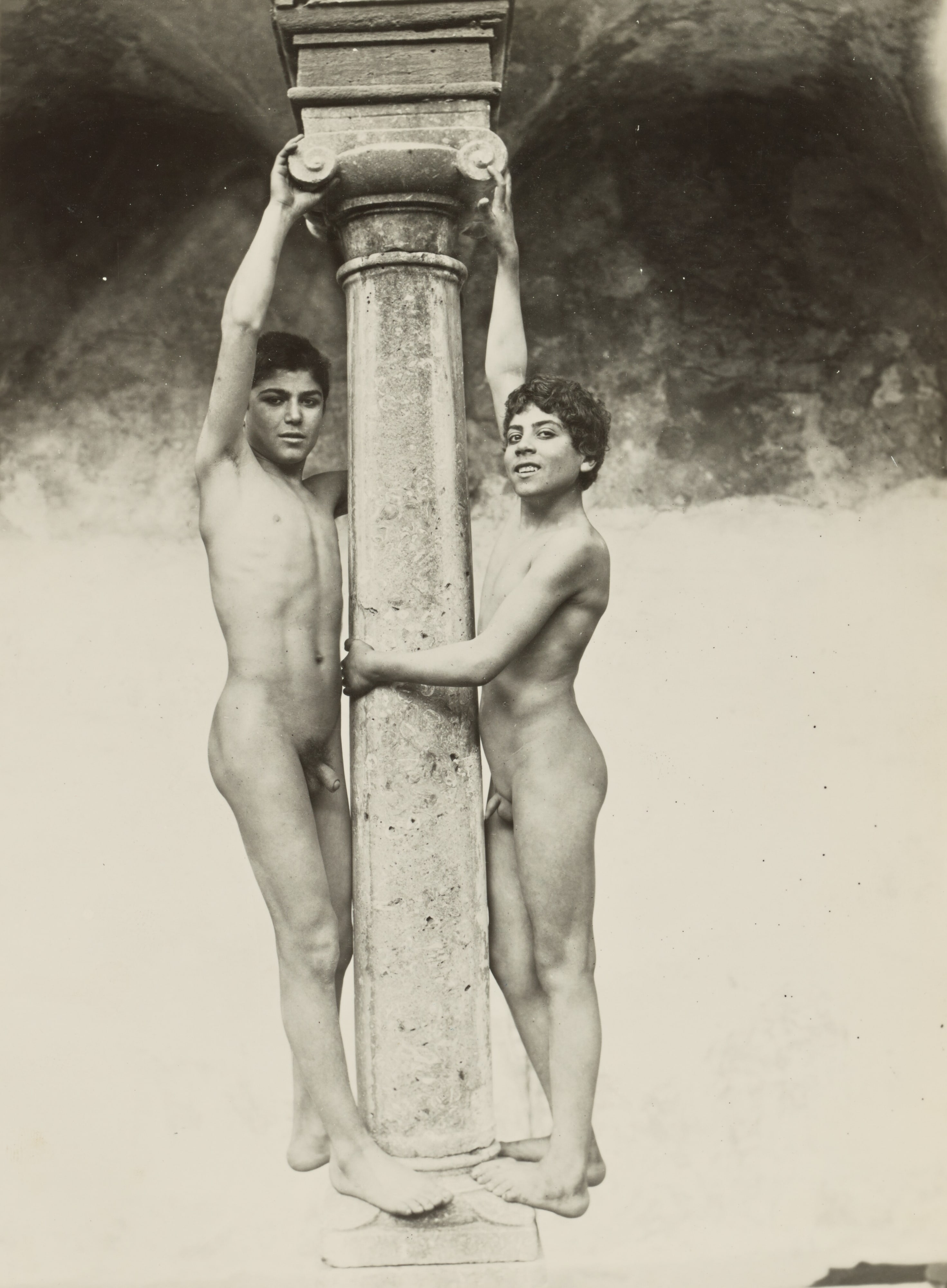[Two Boys Holding onto a Column]