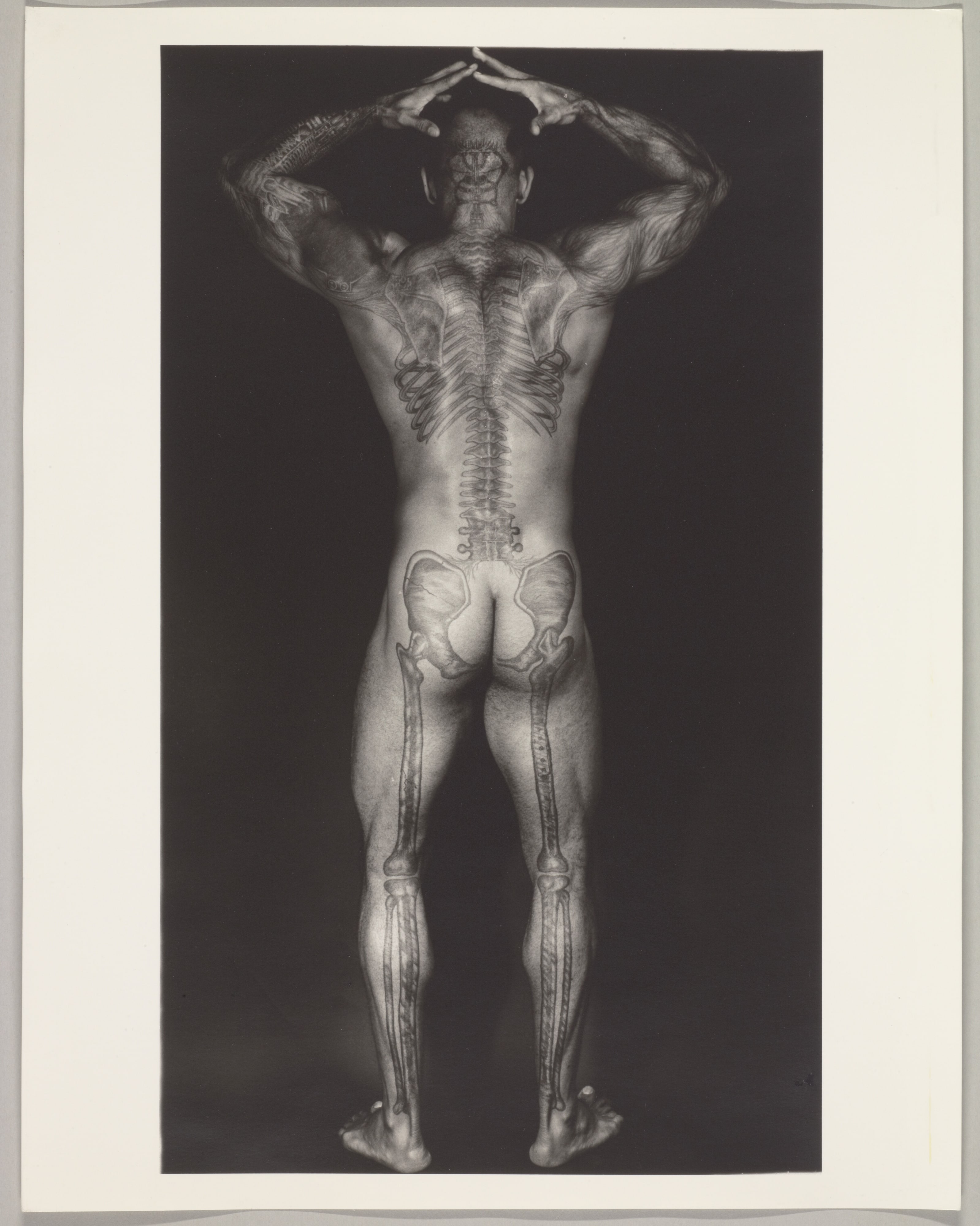 [Tattooed Man with Arms on Head]