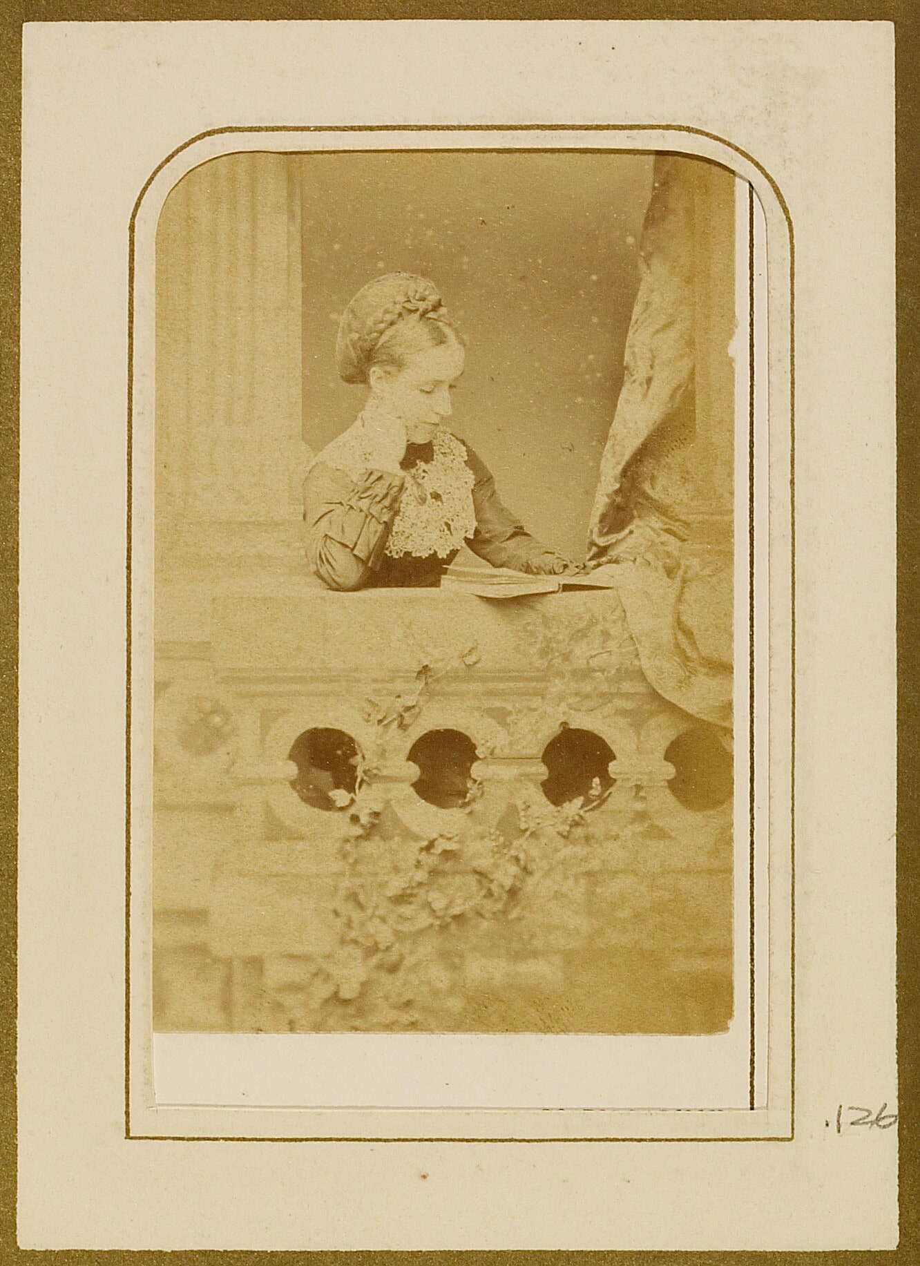 [Portrait of woman reading a book on balcony]