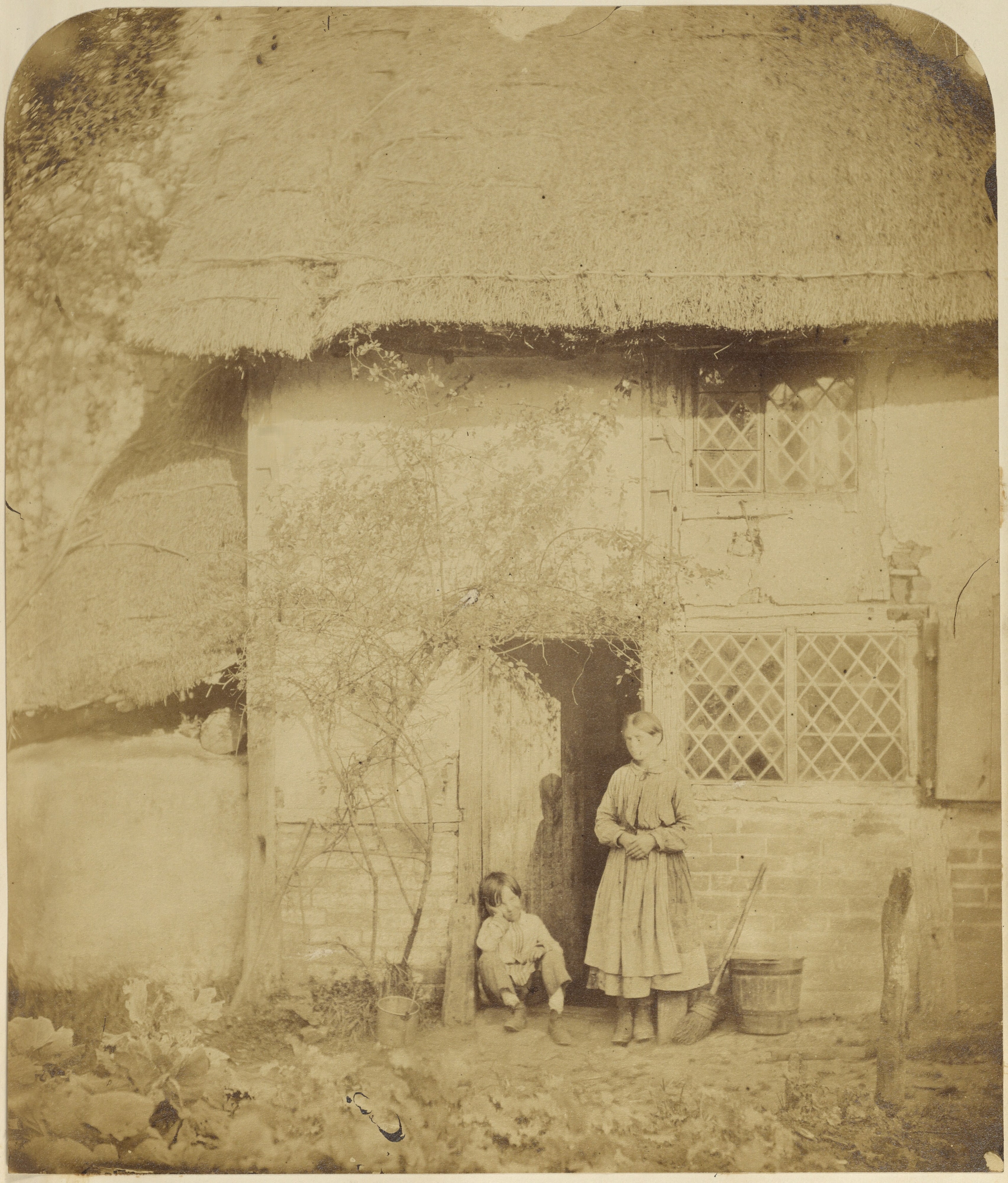 [Woman and boy in front of cottage]