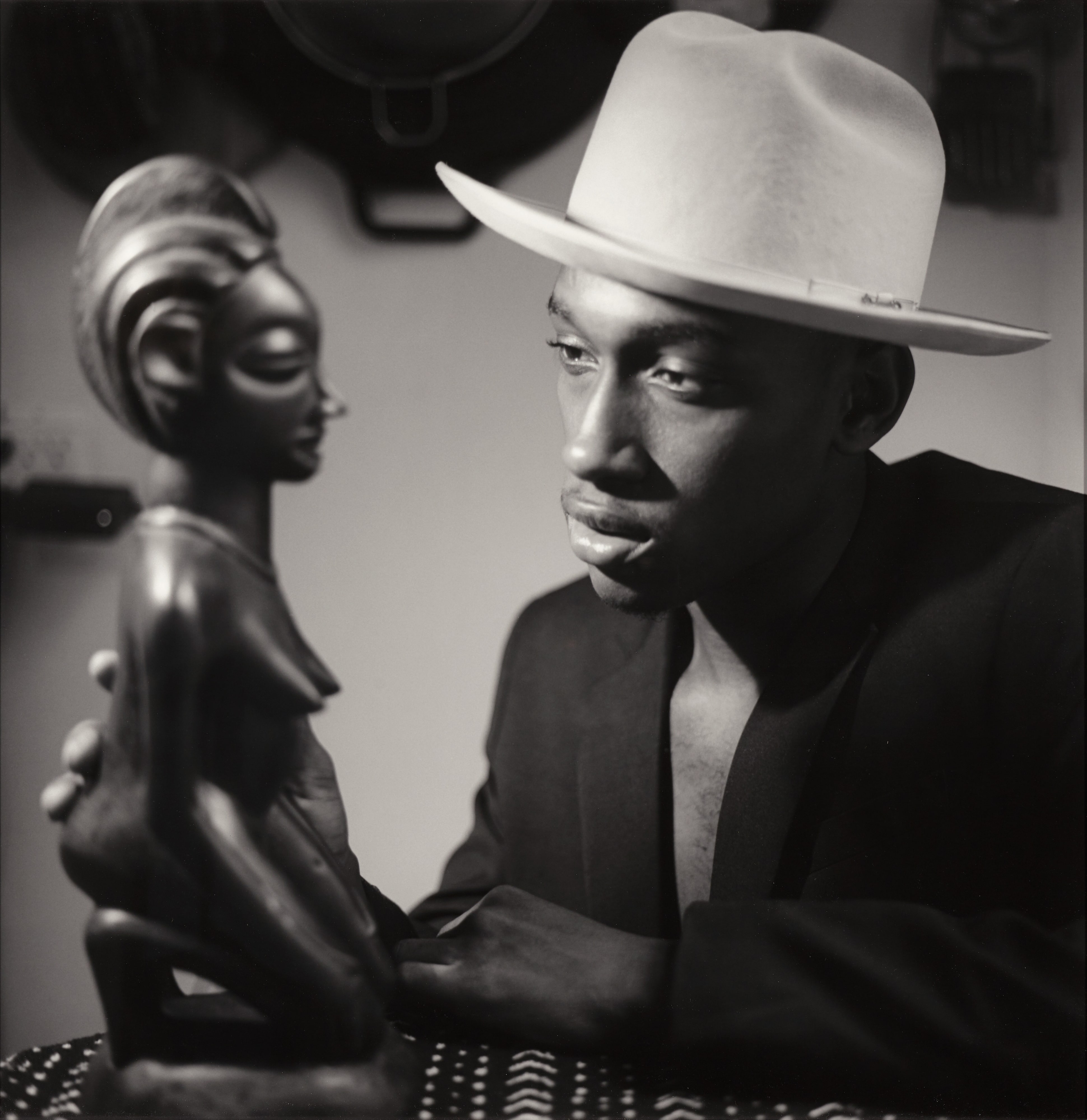 Young man looking at a female sculpture (from the Senufo)