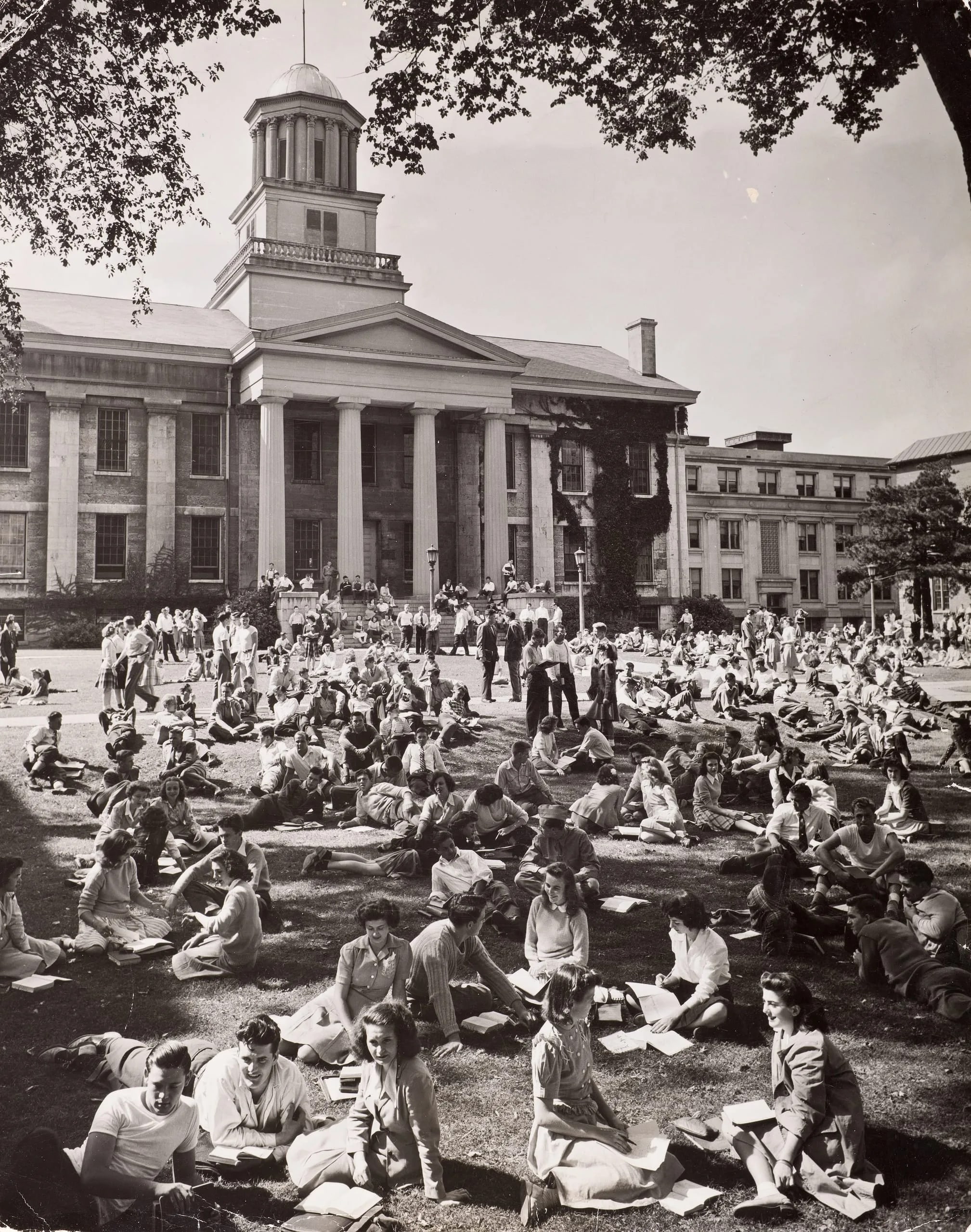 University of Iowa student enjoying a sunny autumn day on lawn in front of Old Capitol of their beautiful campus.  Iowa City, IA, 1942