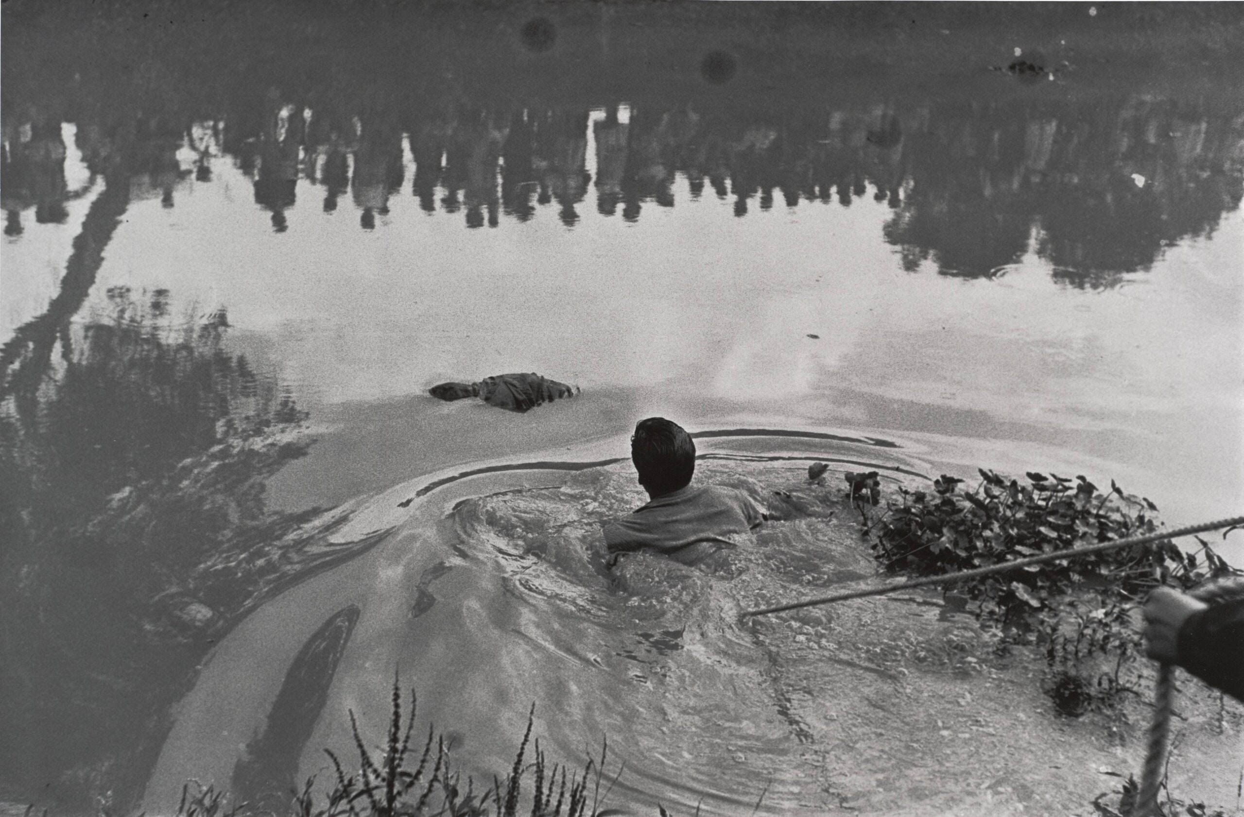 Rescate de un ahogado en Xochimilco con público reflejado en el agua (Retrieval of a drowned body from Lake Xochimilco with the public reflected in the water)