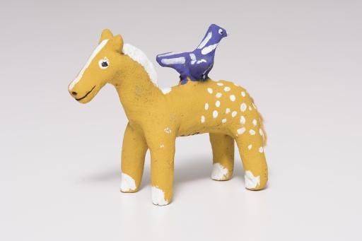 yellow horse with white polka dots and purple bird