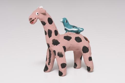 pink giraffe with black dots and green bird