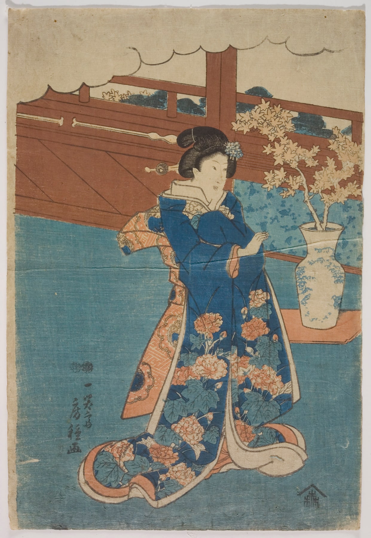 woman standing beside a vase of maple branches