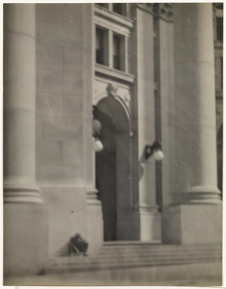 Doorway of building, man seated at side