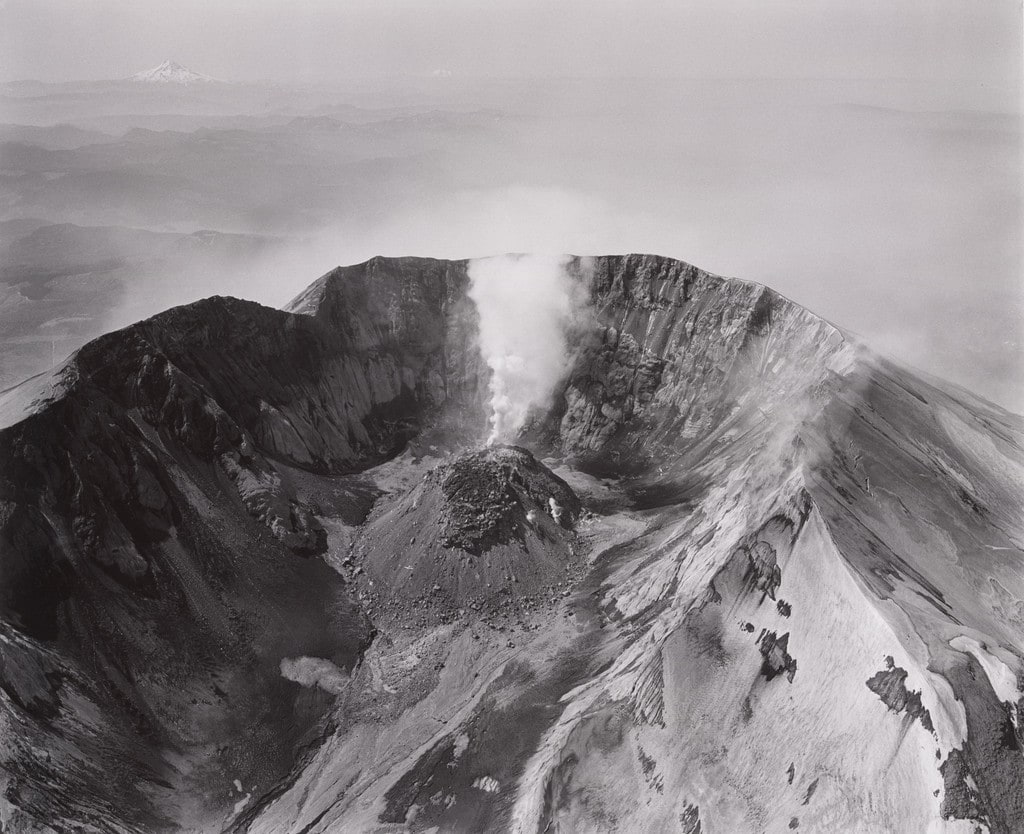 Aerial view: looking south at Mount St. Helens crater and lava dome, Mount Hood and Mount Jefferson in the distance, airplane in crater