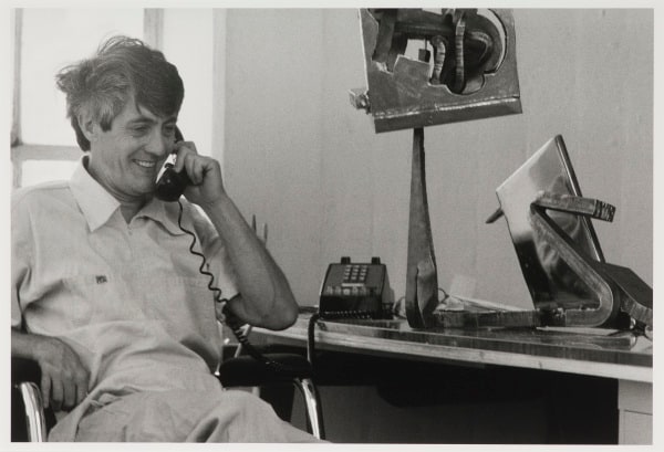 Richard Bellamy with at his Desk with a Mark DiSuvero Sculpture
