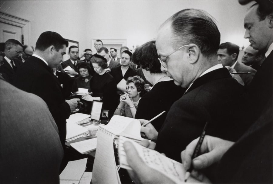 Press Secretary Pierre Salinger speaking to the press and White House officials