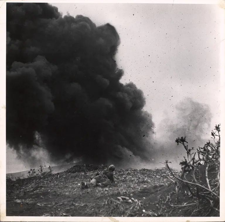 Marines in Iwo Jima: Lone marine lying on ground views demolition charge